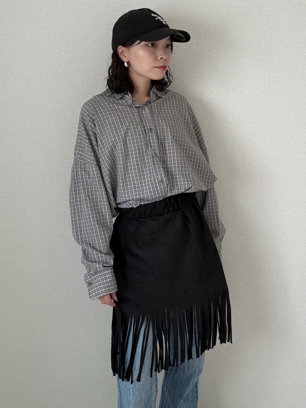 ブラック系のスカート、グレー系のシャツ/ブラウス、ブルー系のデニムパンツを着用したレディースの春コーディネートの4枚目の写真