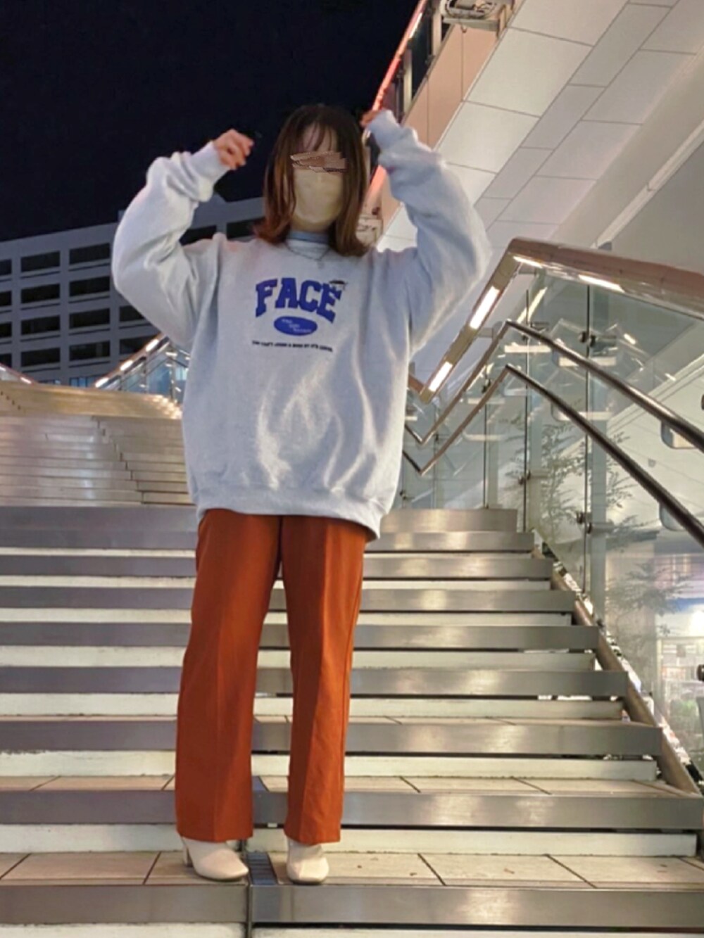 グレー系のスウェット、オレンジ系のスラックス、ホワイト系のブーツを着用したレディースの夏コーディネートの3枚目の写真