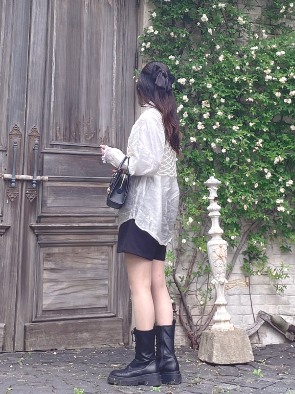 ブラック系のブーツ、ブラック系のその他パンツ、ホワイト系のシャツ/ブラウスを着用したレディースの夏コーディネートの2枚目の写真