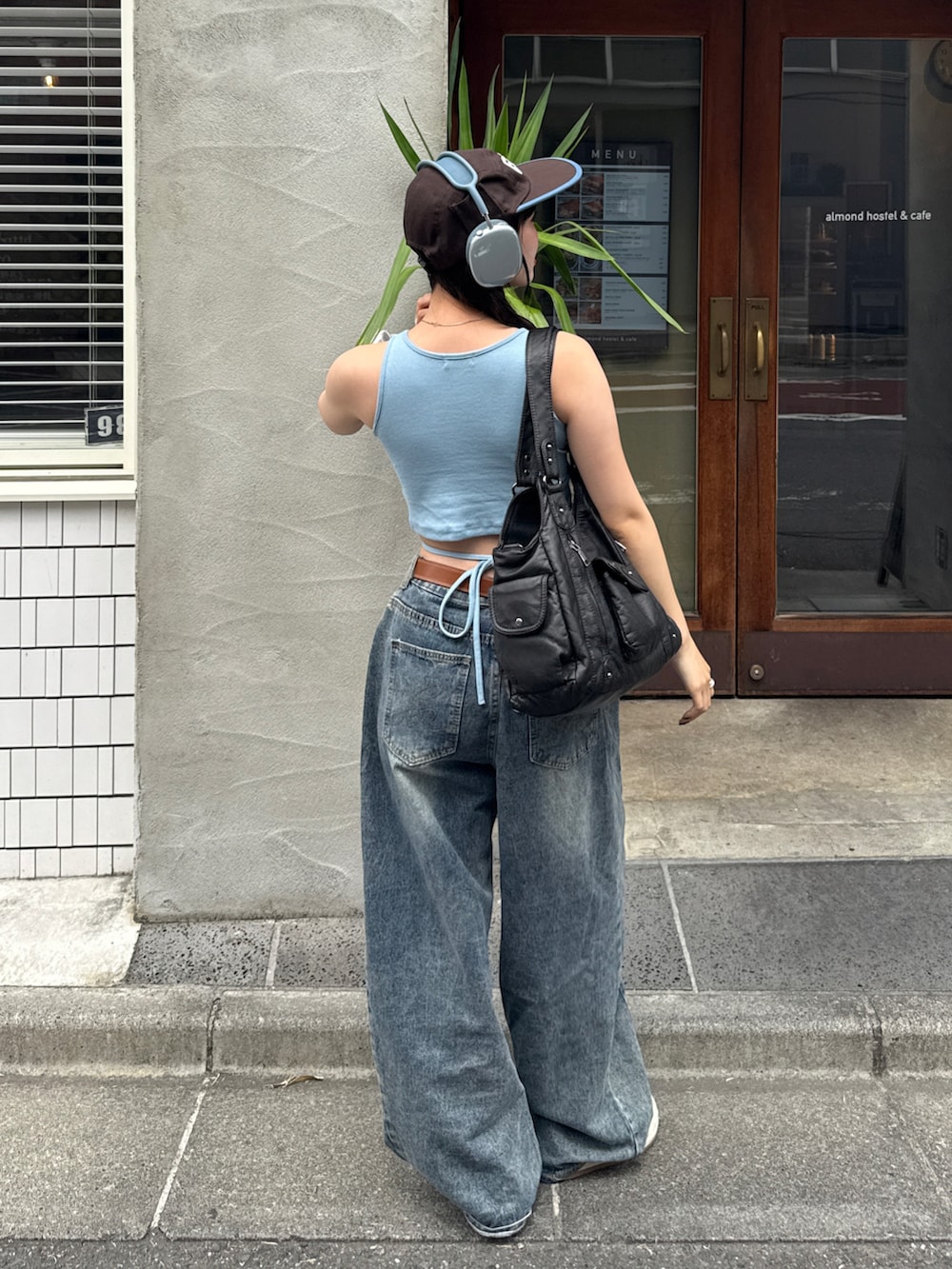 ブルー系のタンクトップ、ブルー系のデニムパンツ、その他のスニーカーを着用したレディースの春コーディネートの2枚目の写真