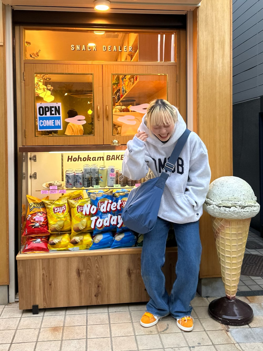 イエロー系のスニーカー、ブルー系のショルダーバッグを着用したレディースの春コーディネートの5枚目の写真