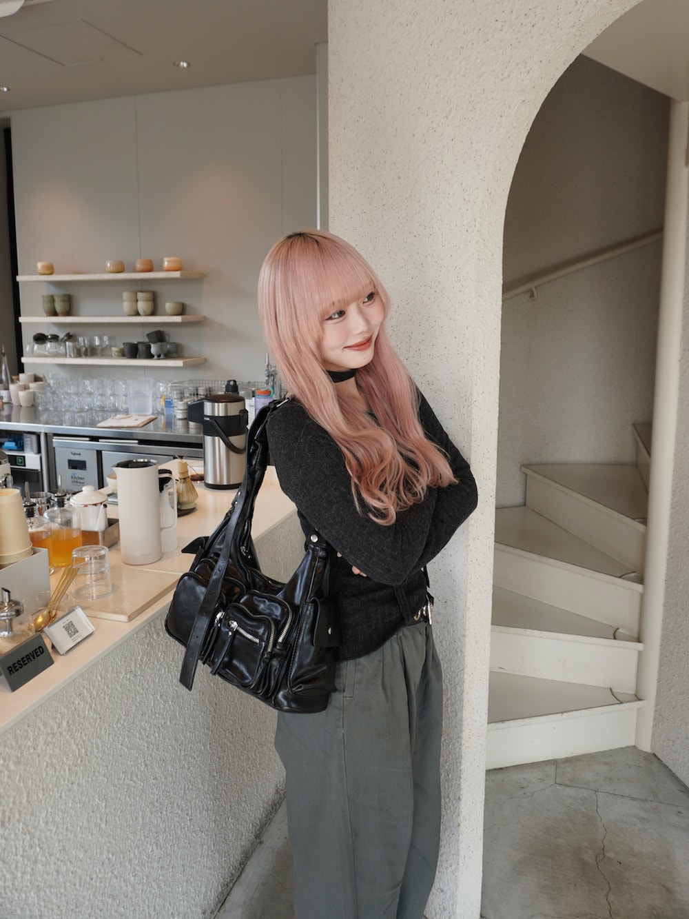 グレー系のパンツ、グレー系のトップス、ブラック系のスニーカーを着用したレディースの冬コーディネートの2枚目の写真