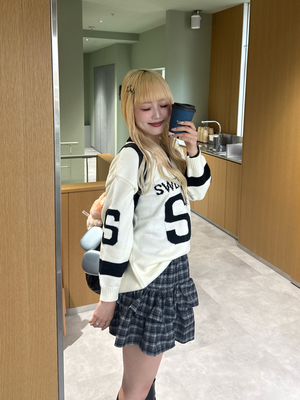 グレー系のニット/セーター、その他のスカート、ブラック系のブーツを着用したレディースの秋コーディネートの2枚目の写真