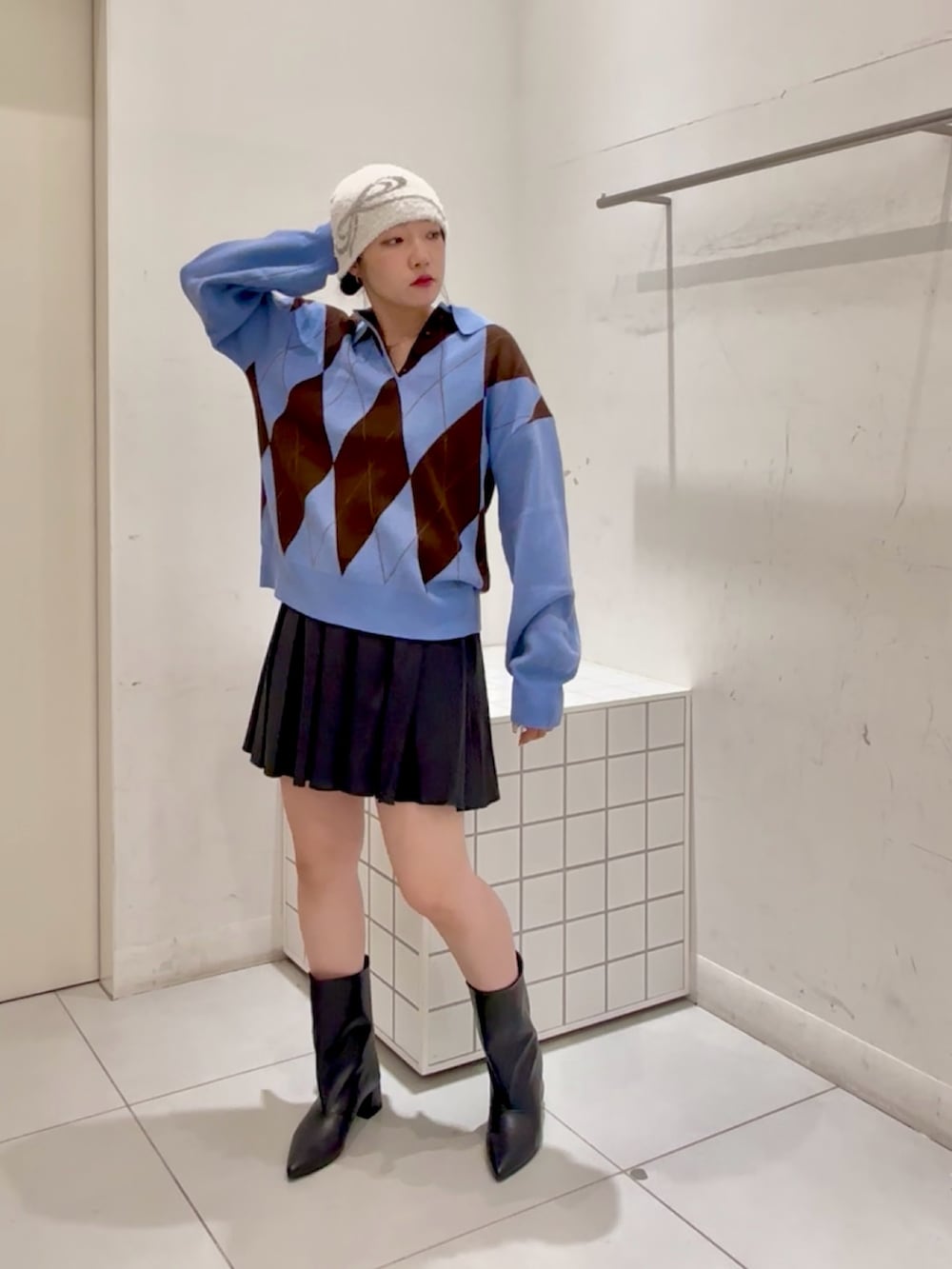 ブルー系のニット/セーター、グリーン系のワンピース、ブラック系のブーツを着用したレディースの秋コーディネートの2枚目の写真