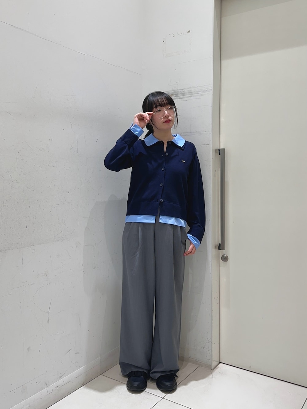 ブルー系のカーディガン/ボレロ、グレー系のスラックス、ブラック系のサンダルを着用したレディースの春コーディネートの2枚目の写真