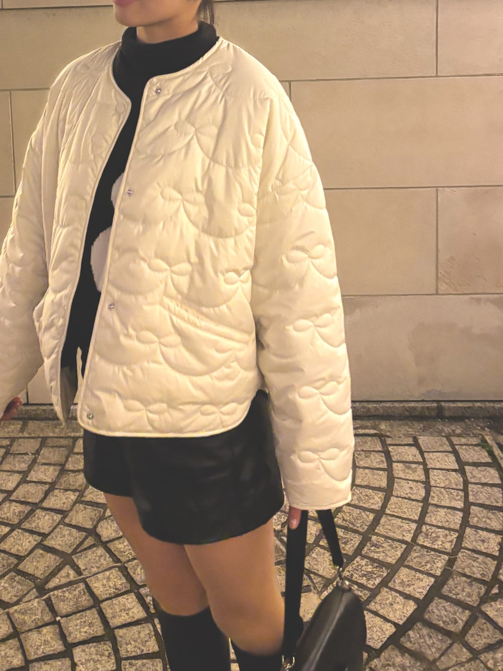 ホワイト系のその他アウター、ブラック系のその他パンツ、ブラック系のブーティを着用したレディースの冬コーディネートの2枚目の写真