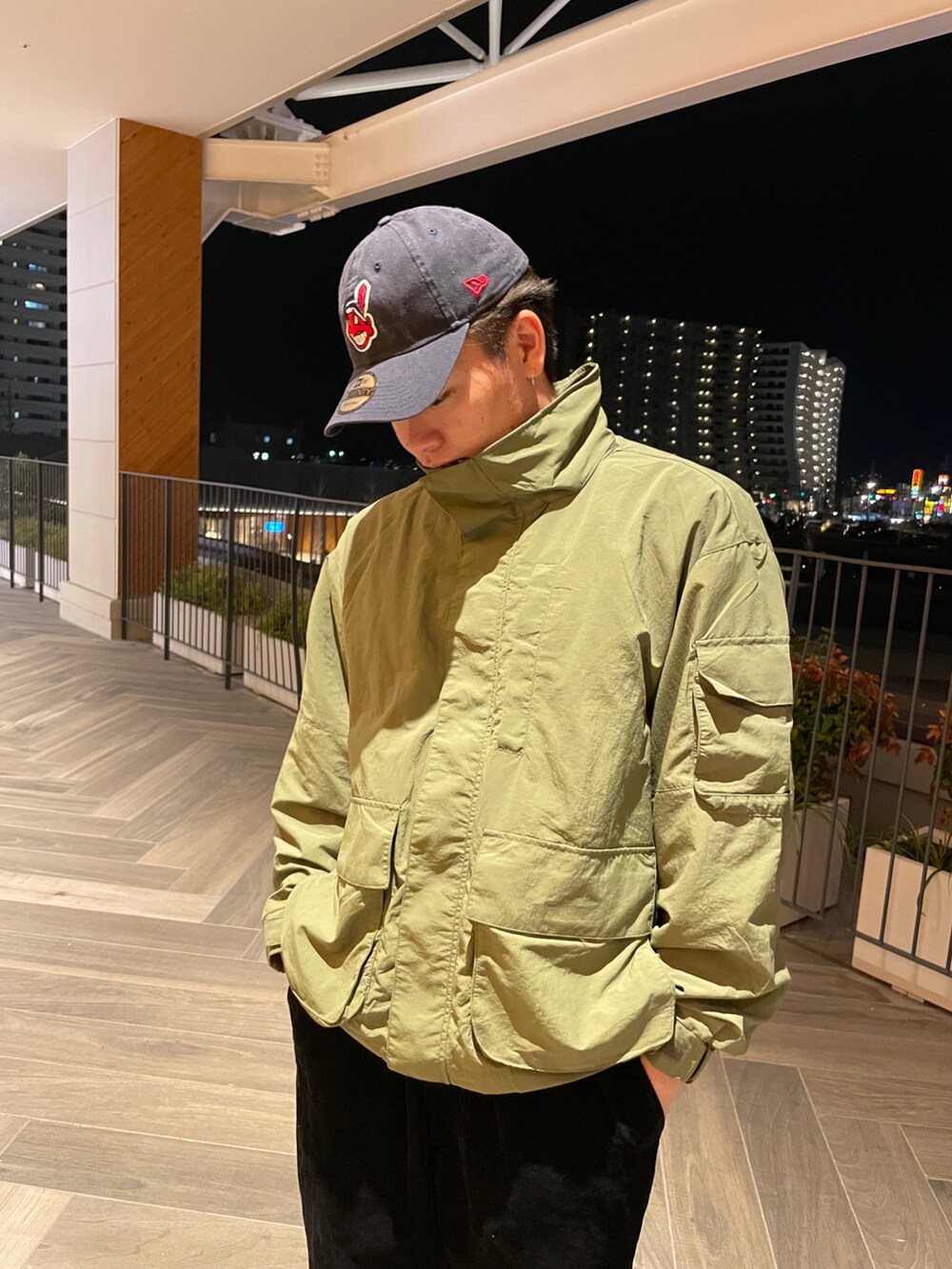 ブラック系のパンツ、ブラック系のシューズ、グリーン系のブルゾンを着用したメンズの春コーディネートの2枚目の写真