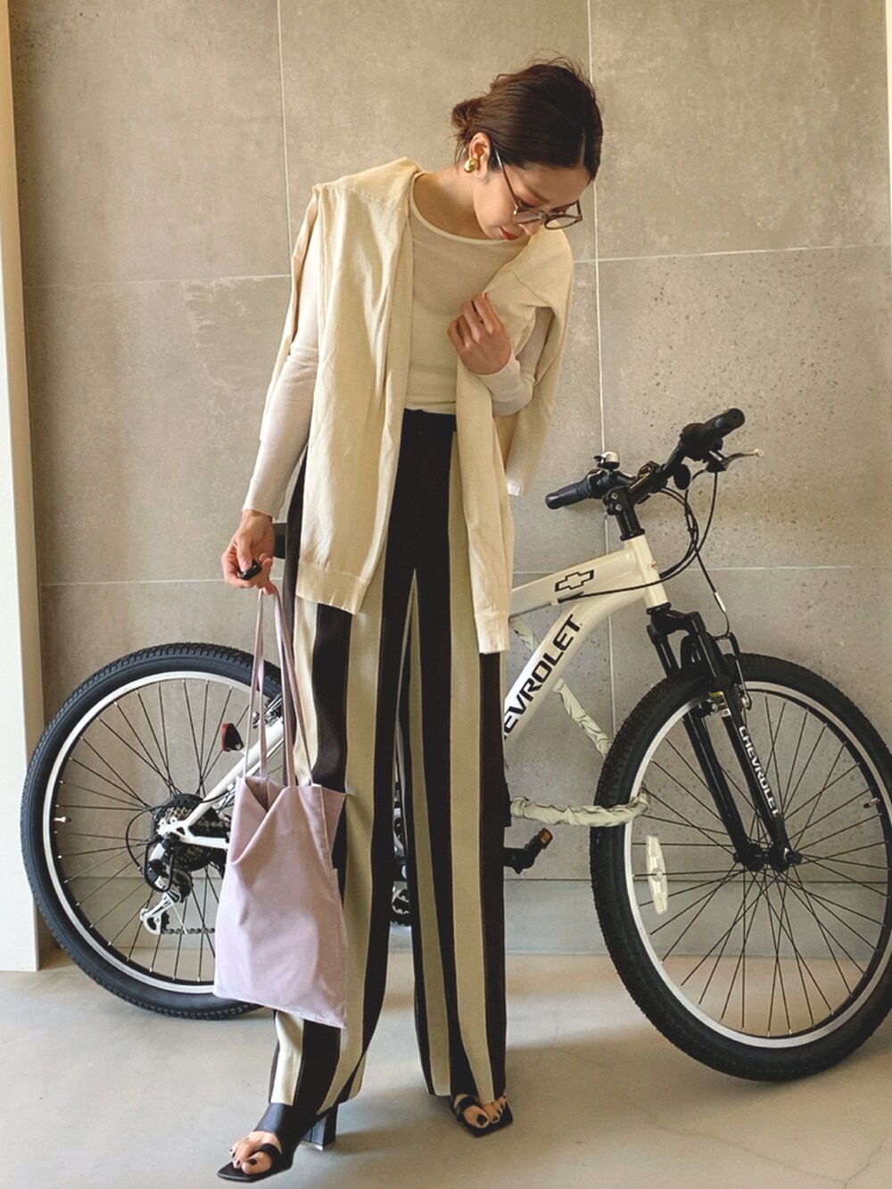 グリーン系のトートバッグ、ブラウン系のその他パンツ、ホワイト系のTシャツ/カットソーを着用したレディースの春コーディネートの2枚目の写真