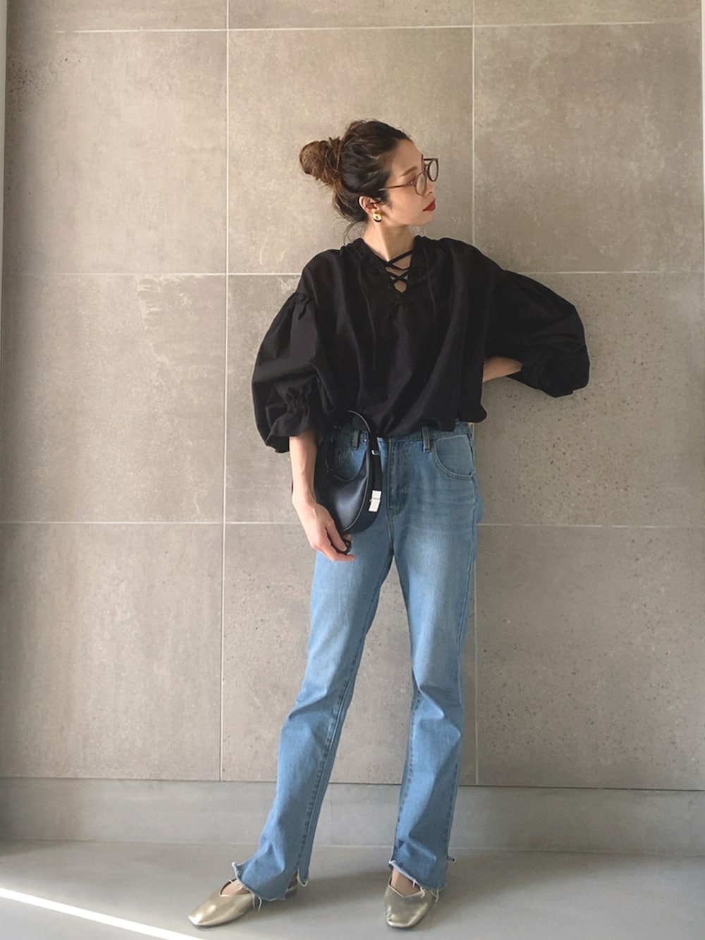 ブラック系のシャツ/ブラウス、ブラック系のハンドバッグ、ブラック系のデニムパンツを着用したレディースの春コーディネートの3枚目の写真