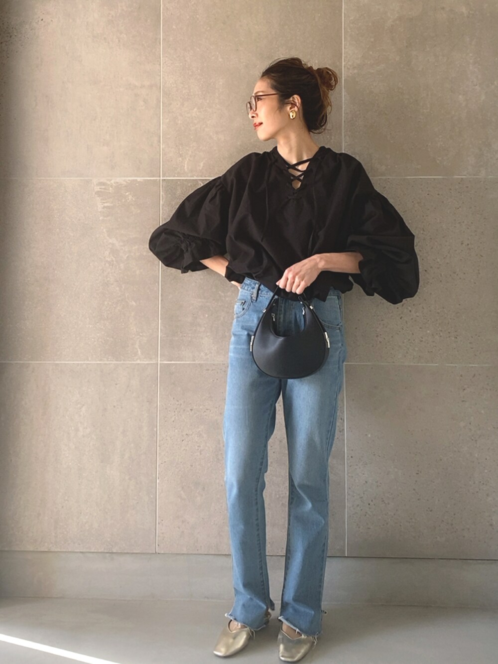 ブラック系のシャツ/ブラウス、ブラック系のハンドバッグ、ブラック系のデニムパンツを着用したレディースの春コーディネートの2枚目の写真