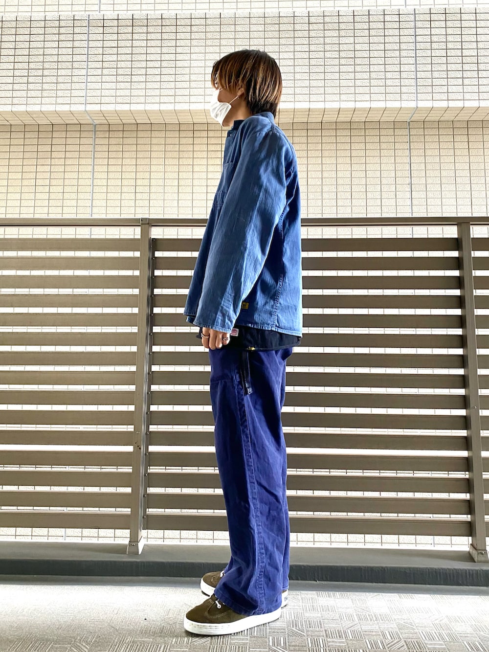 ブルー系のカバーオール、ブラック系のTシャツ/カットソー、ブルー系のチノパンツを着用したメンズの春コーディネートの2枚目の写真