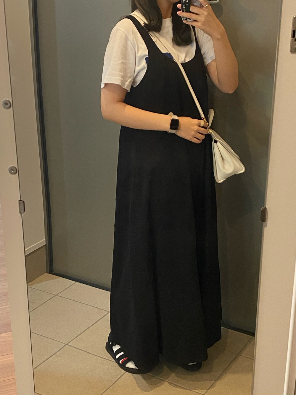 ブラック系のオールインワン・サロペット、ホワイト系のバッグ、ホワイト系のTシャツ/カットソーを着用したレディースの春コーディネートの2枚目の写真