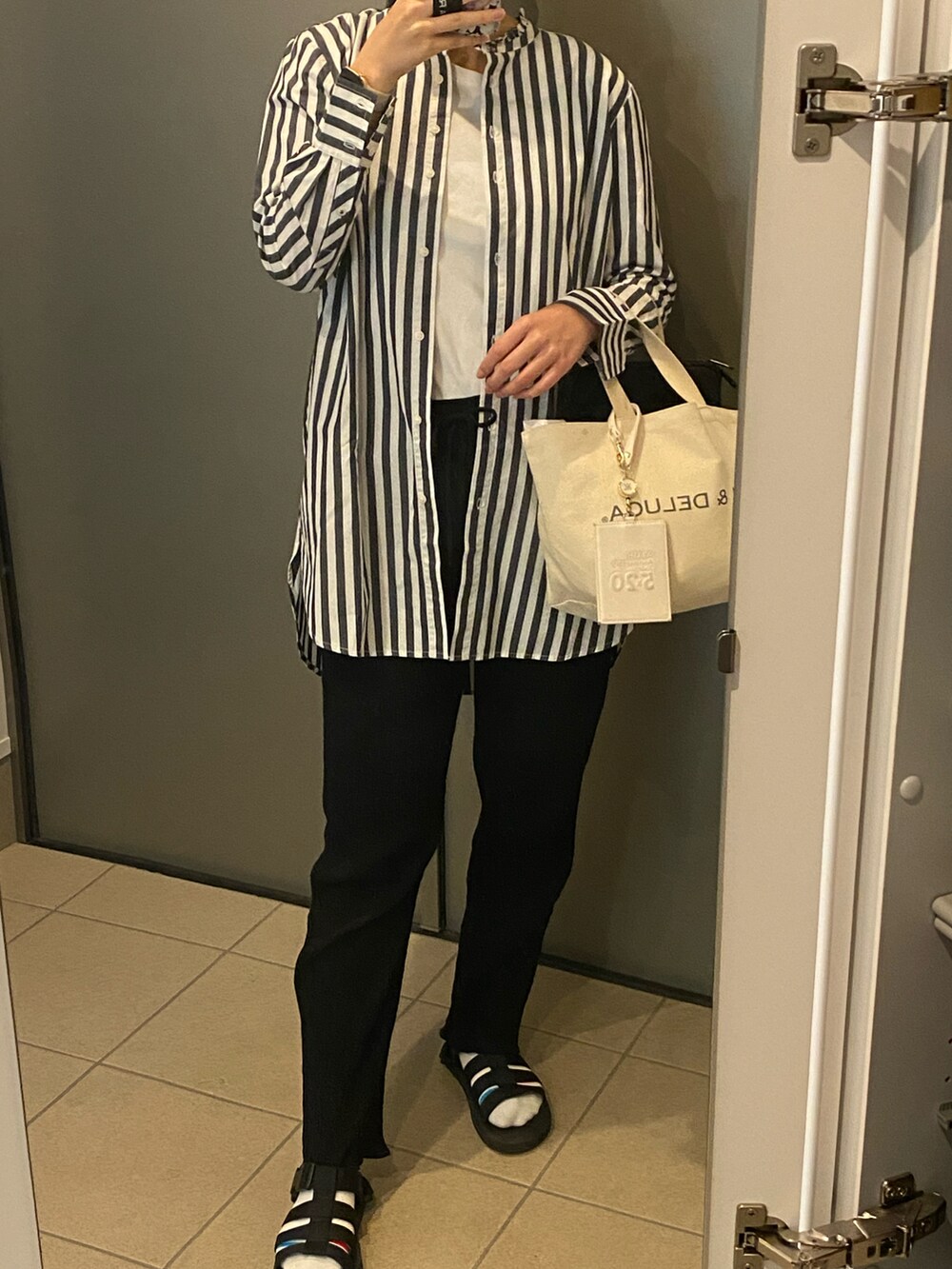 ホワイト系のバッグ、ブラック系のパンツ、ホワイト系のシャツ/ブラウスを着用したレディースの春コーディネートの2枚目の写真