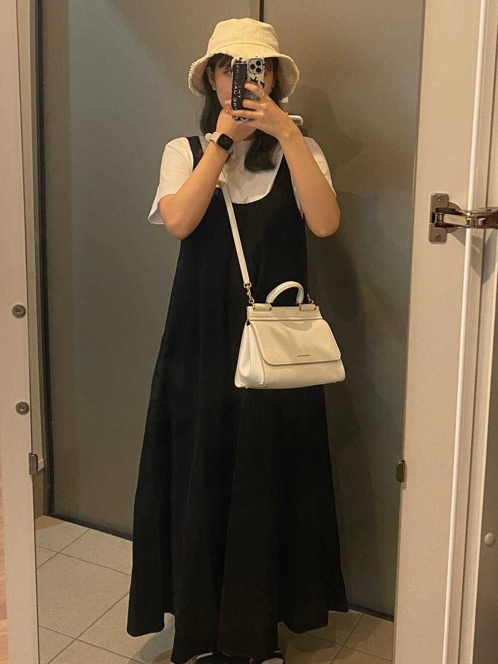 ブラック系のオールインワン・サロペット、ホワイト系のバッグ、ホワイト系のTシャツ/カットソーを着用したレディースの春コーディネートの3枚目の写真