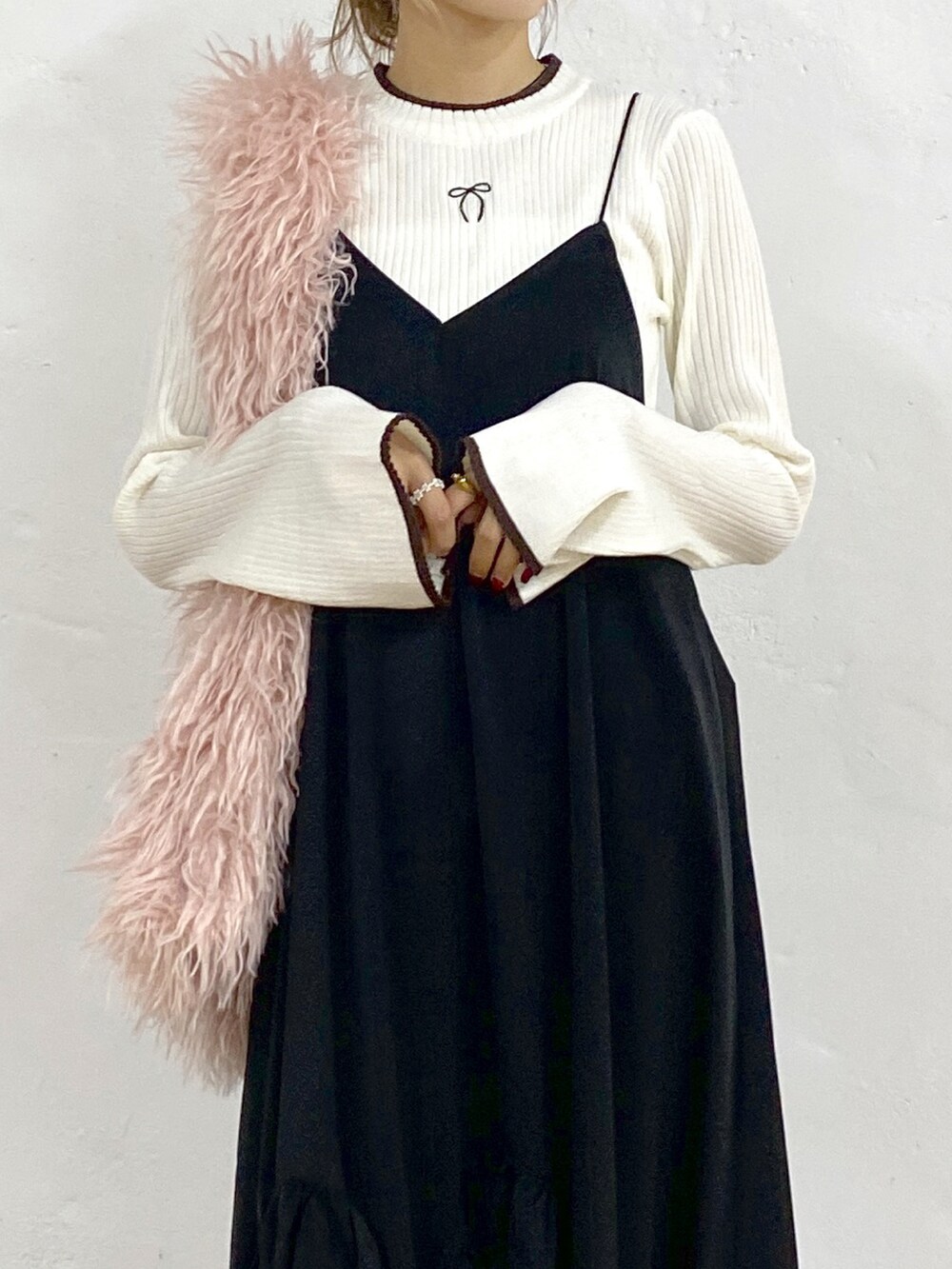 ブラック系のワンピース、ホワイト系のニット/セーター、ブラック系のスニーカーを着用したレディースの秋コーディネートの4枚目の写真