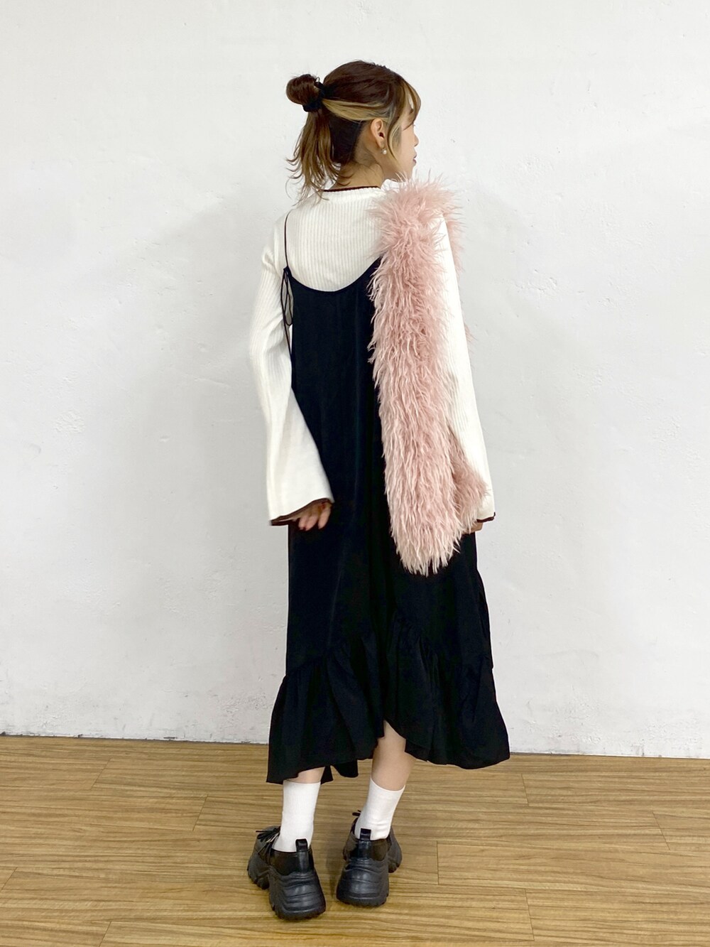 ブラック系のワンピース、ホワイト系のニット/セーター、ブラック系のスニーカーを着用したレディースの秋コーディネートの3枚目の写真