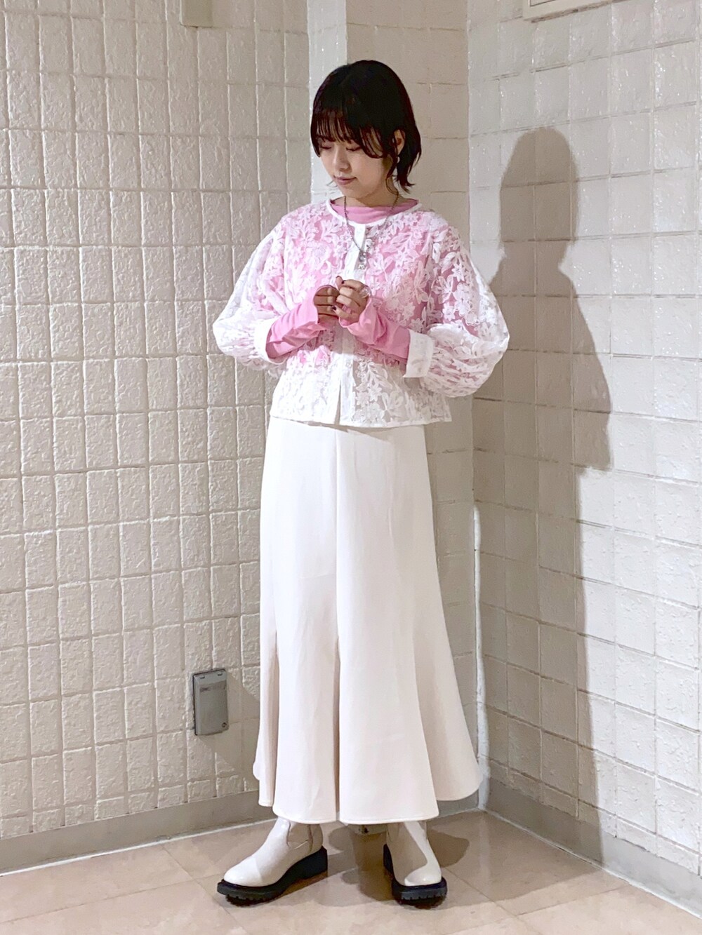 ホワイト系のスカート、ホワイト系のシャツ/ブラウス、ピンク系のTシャツ/カットソーを着用したレディースの春コーディネートの2枚目の写真