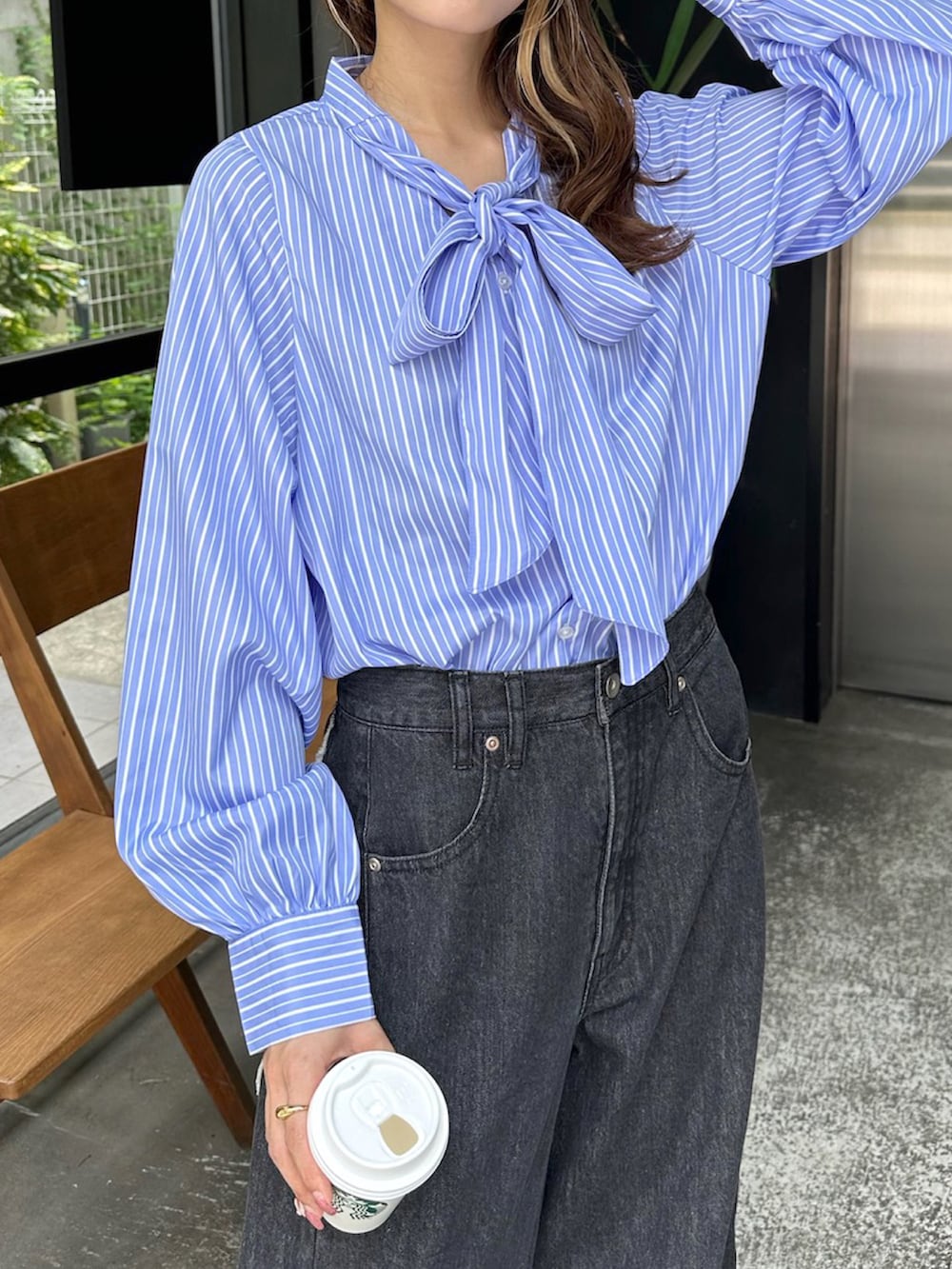 ブルー系のシャツ/ブラウス、ブラック系のデニムパンツ、ブラック系のブーツを着用したレディースの秋コーディネートの4枚目の写真
