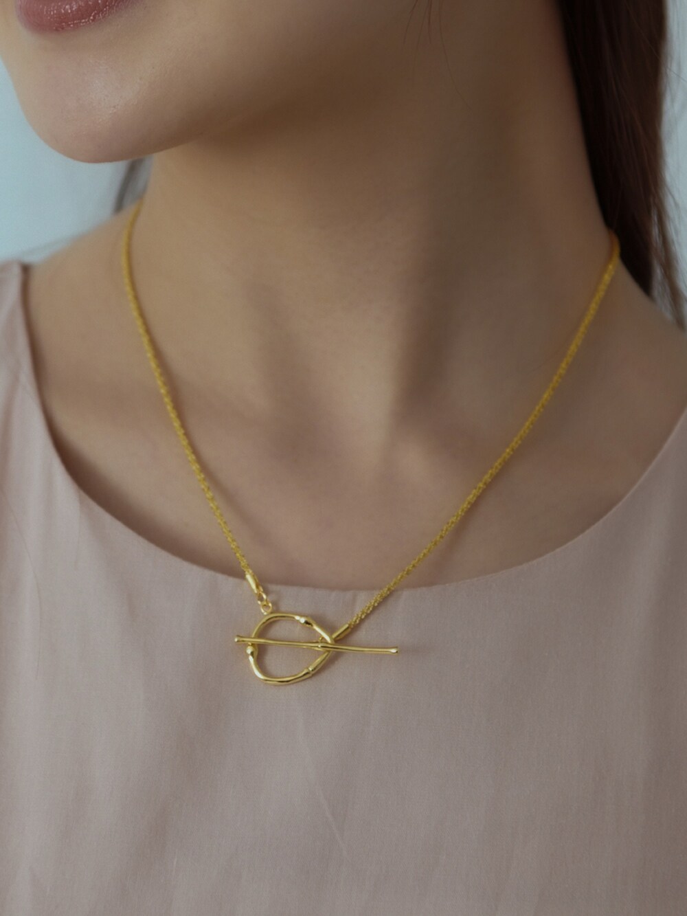 ブラック系のショルダーバッグ、ブラック系のサンダル、ベージュ系のワンピースを着用したレディースの夏コーディネートの2枚目の写真