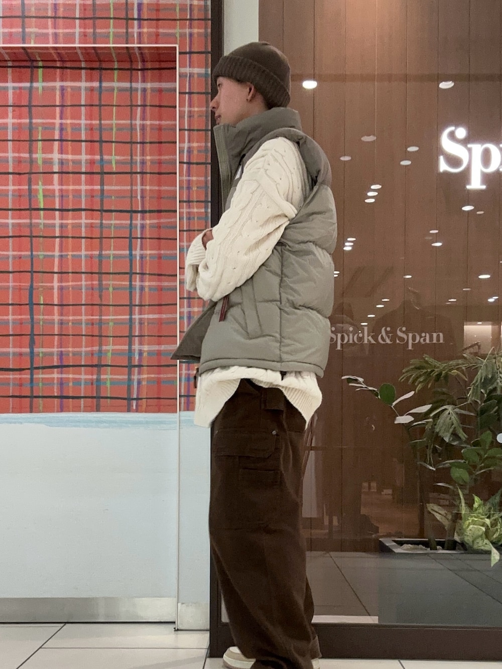 グレー系のダウンベスト、グレー系のニットキャップ/ビーニーを着用したメンズの冬コーディネートの3枚目の写真