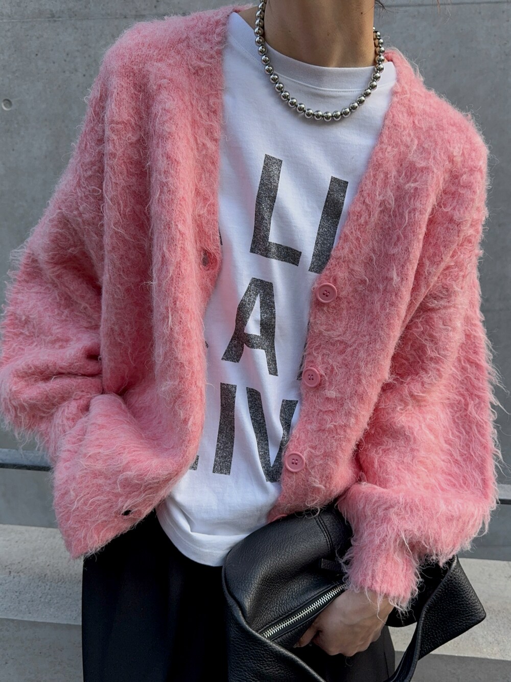 ブラック系のブーツ、ブラック系のスラックス、ブラック系のハンドバッグを着用したレディースの冬コーディネートの2枚目の写真