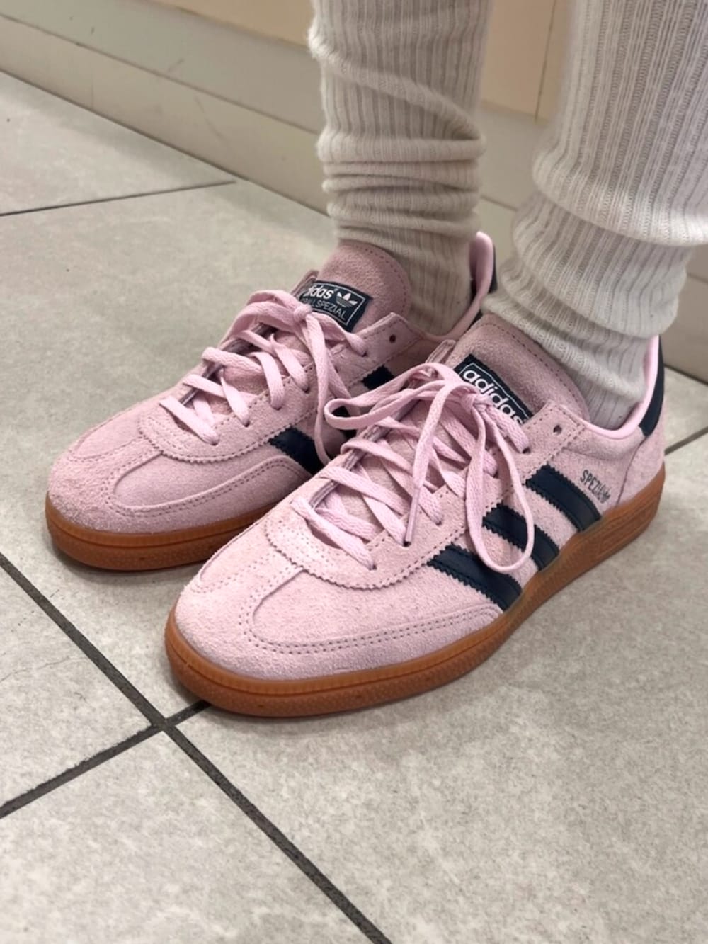 ピンク系のスニーカー、ブルー系のデニムパンツ、ホワイト系のタンクトップを着用したレディースの夏コーディネートの2枚目の写真