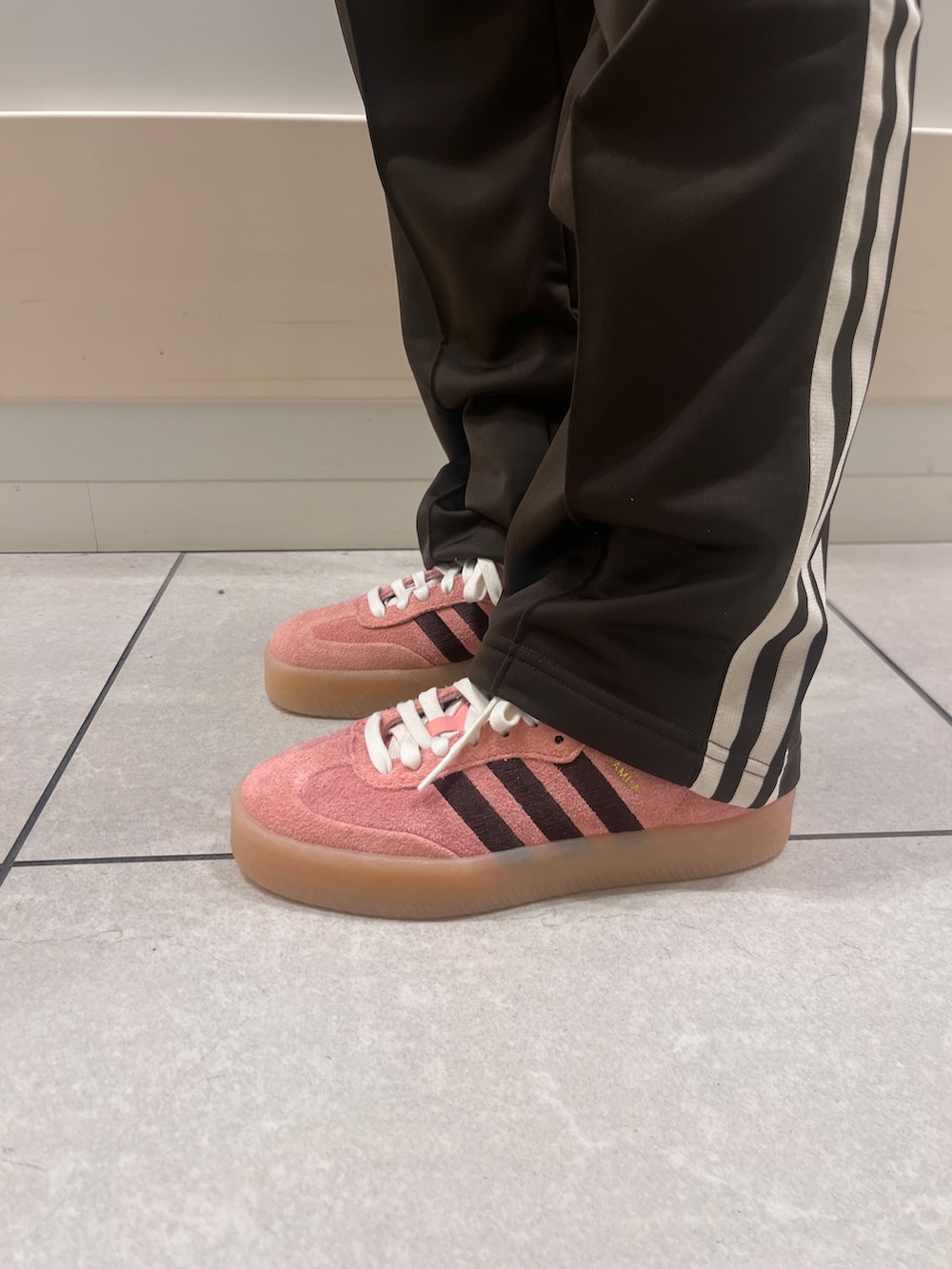 ピンク系のスニーカー、ピンク系のトップス、ブラウン系のスウェットパンツを着用したレディースの冬コーディネートの3枚目の写真