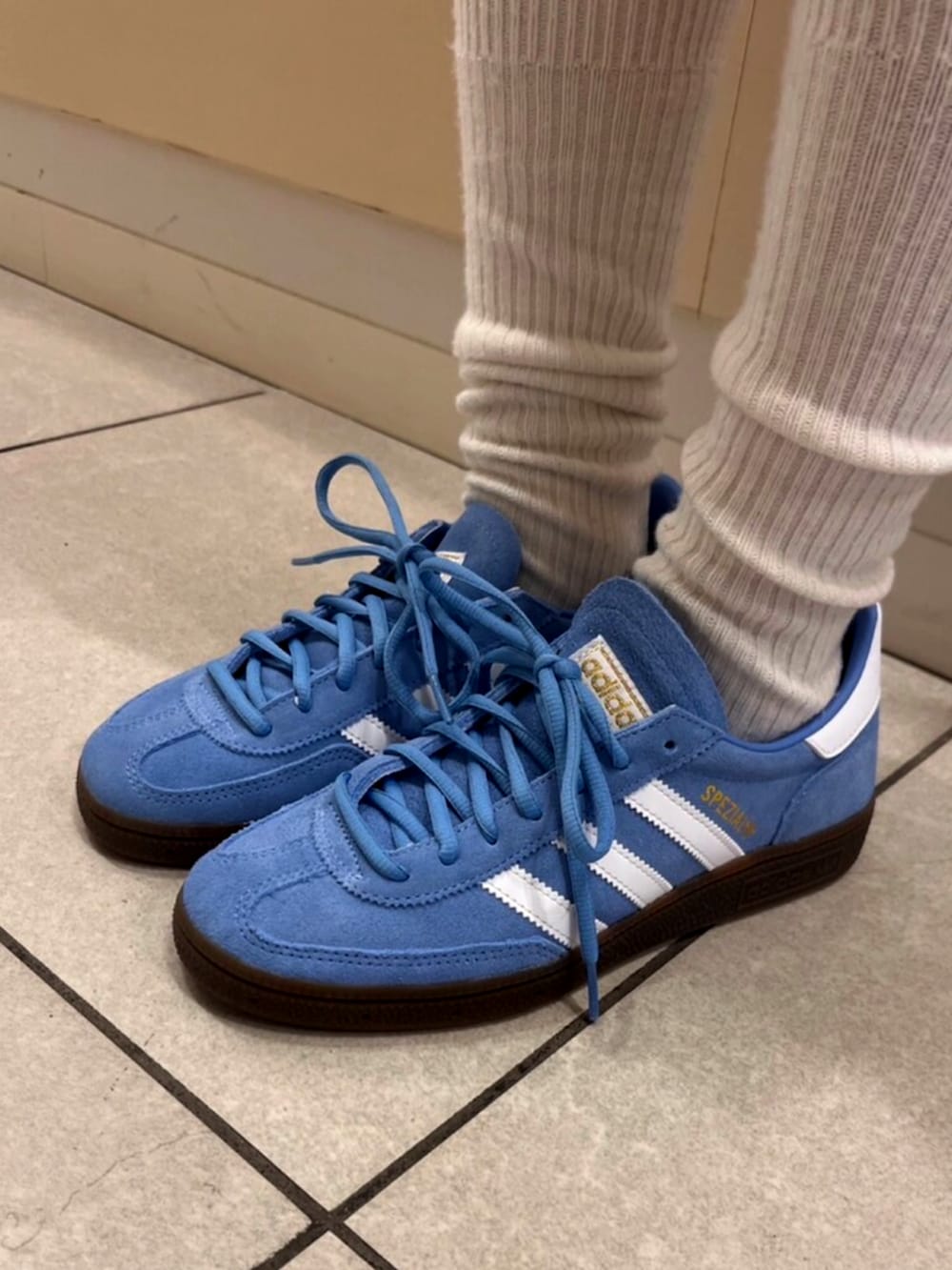 ホワイト系のトップス、ブルー系のスニーカーを着用したレディースの夏コーディネートの2枚目の写真