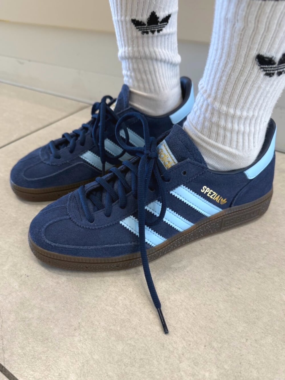 ホワイト系のトップス、ブルー系のデニムパンツ、ブルー系のスニーカーを着用したレディースの夏コーディネートの2枚目の写真