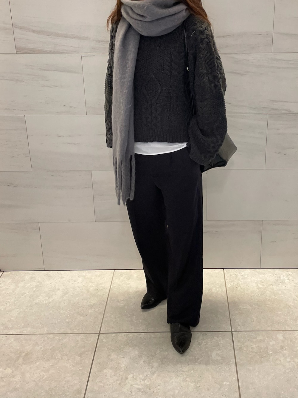 ブラック系のニット/セーター、ブラック系のスラックス、ブラック系のパンプスを着用したレディースの冬コーディネートの3枚目の写真