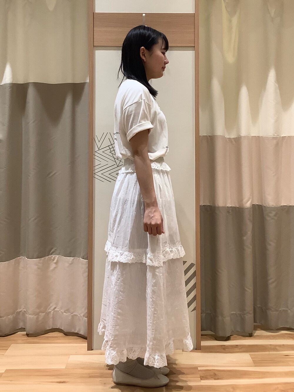 ホワイト系のスカート、ホワイト系のTシャツ/カットソー、ホワイト系のパンプスを着用したレディースの春コーディネートの2枚目の写真