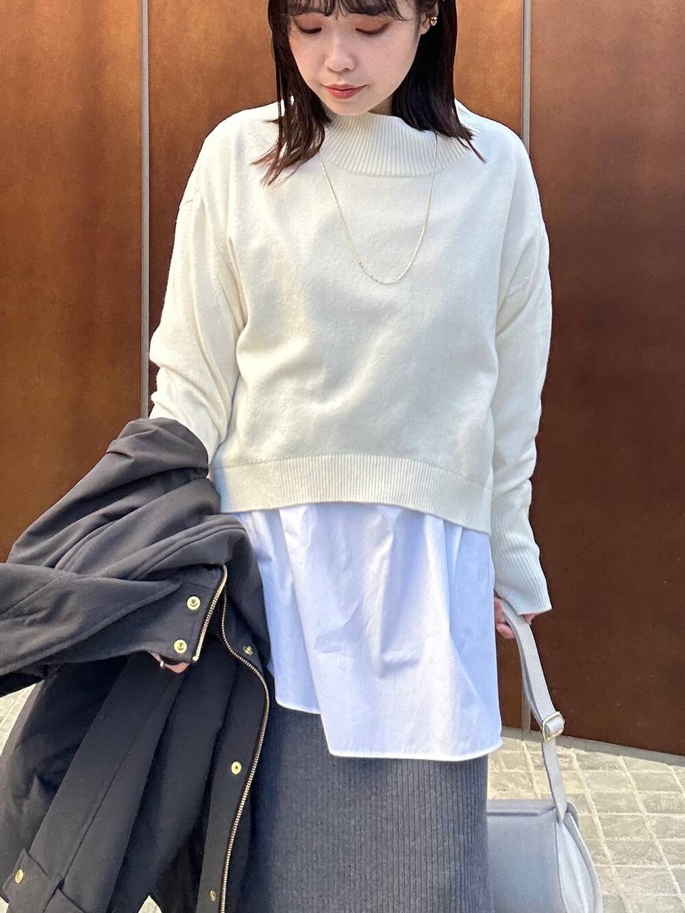 ホワイト系のシャツ/ブラウス、グレー系のスカート、ホワイト系のニット/セーターを着用したレディースの冬コーディネートの3枚目の写真