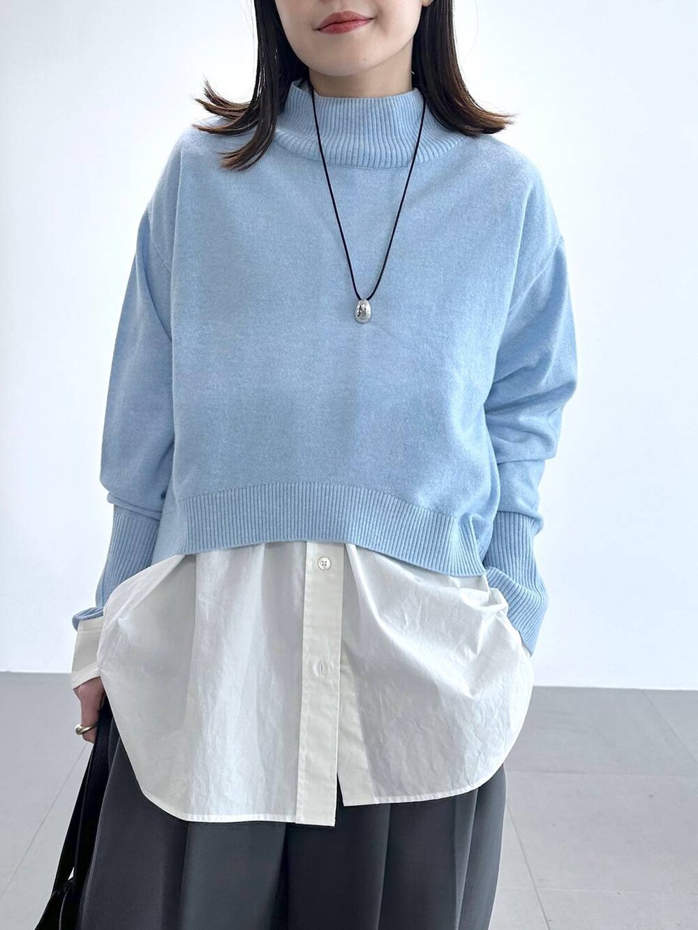 グレー系のその他パンツ、ホワイト系のシャツ/ブラウス、ブルー系のニット/セーターを着用したレディースの冬コーディネートの4枚目の写真