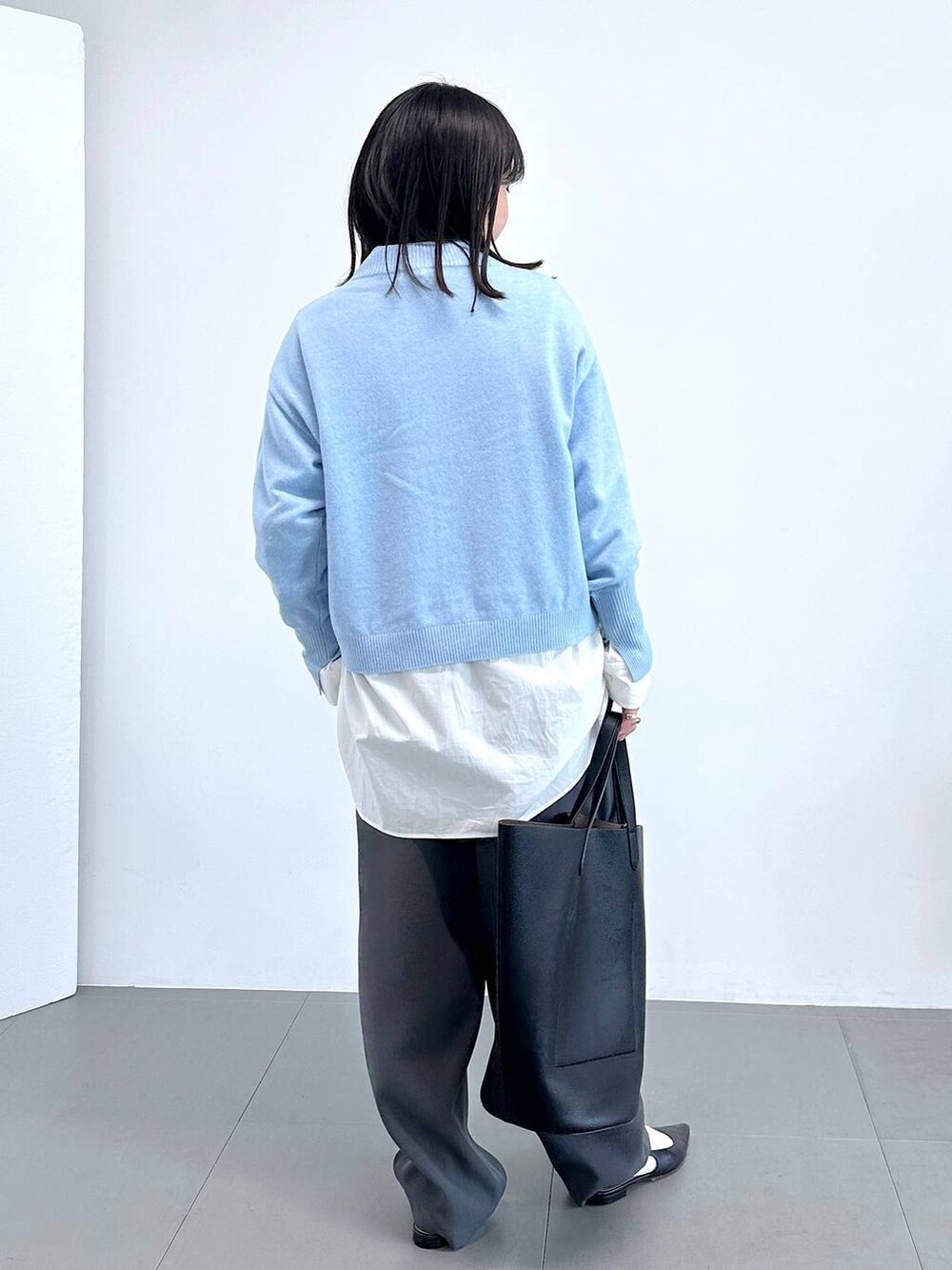 グレー系のその他パンツ、ホワイト系のシャツ/ブラウス、ブルー系のニット/セーターを着用したレディースの冬コーディネートの3枚目の写真