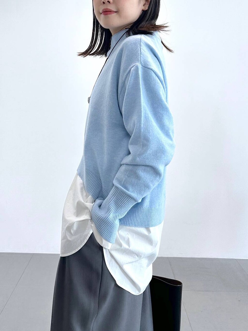 グレー系のその他パンツ、ホワイト系のシャツ/ブラウス、ブルー系のニット/セーターを着用したレディースの冬コーディネートの5枚目の写真