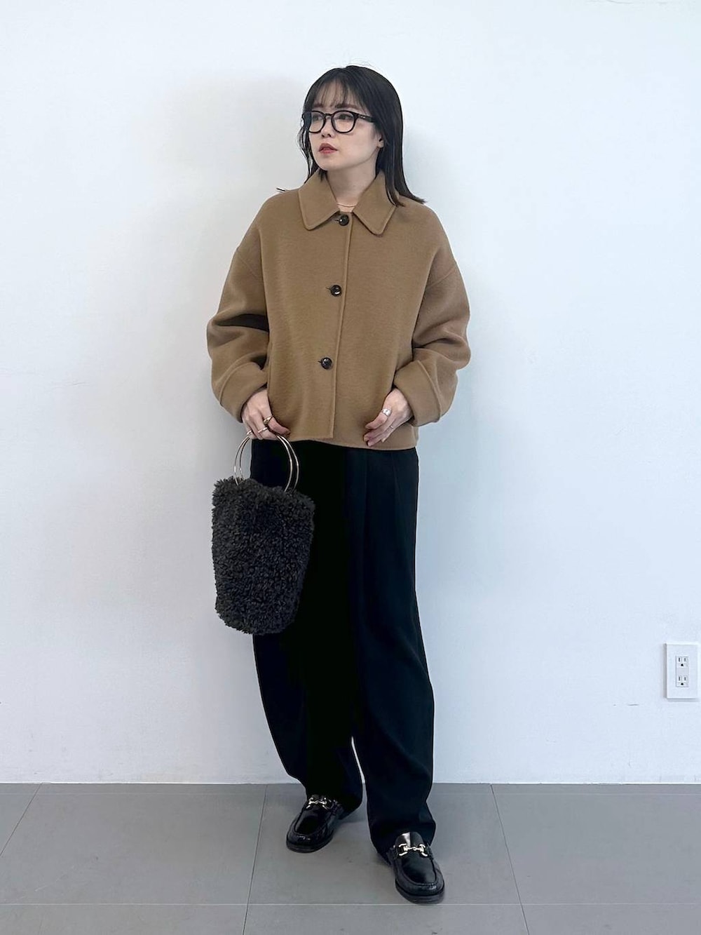 グレー系のハンドバッグ、ブラック系のその他パンツ、ホワイト系のニット/セーターを着用したレディースの冬コーディネートの4枚目の写真