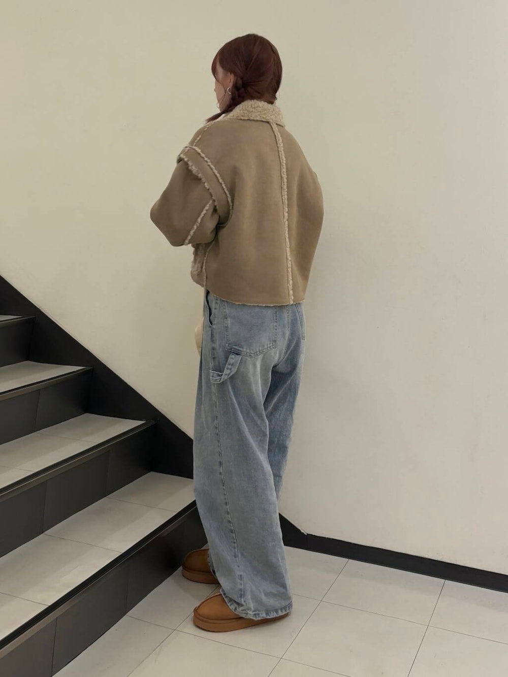 ブルー系のデニムパンツ、ベージュ系のその他アウター、ホワイト系のショルダーバッグを着用したレディースの秋コーディネートの5枚目の写真