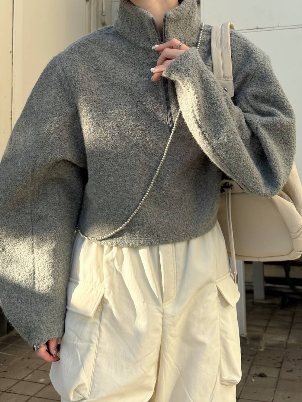 ブラック系のブーツ、ホワイト系のショルダーバッグ、ホワイト系のその他パンツを着用したレディースの冬コーディネートの3枚目の写真