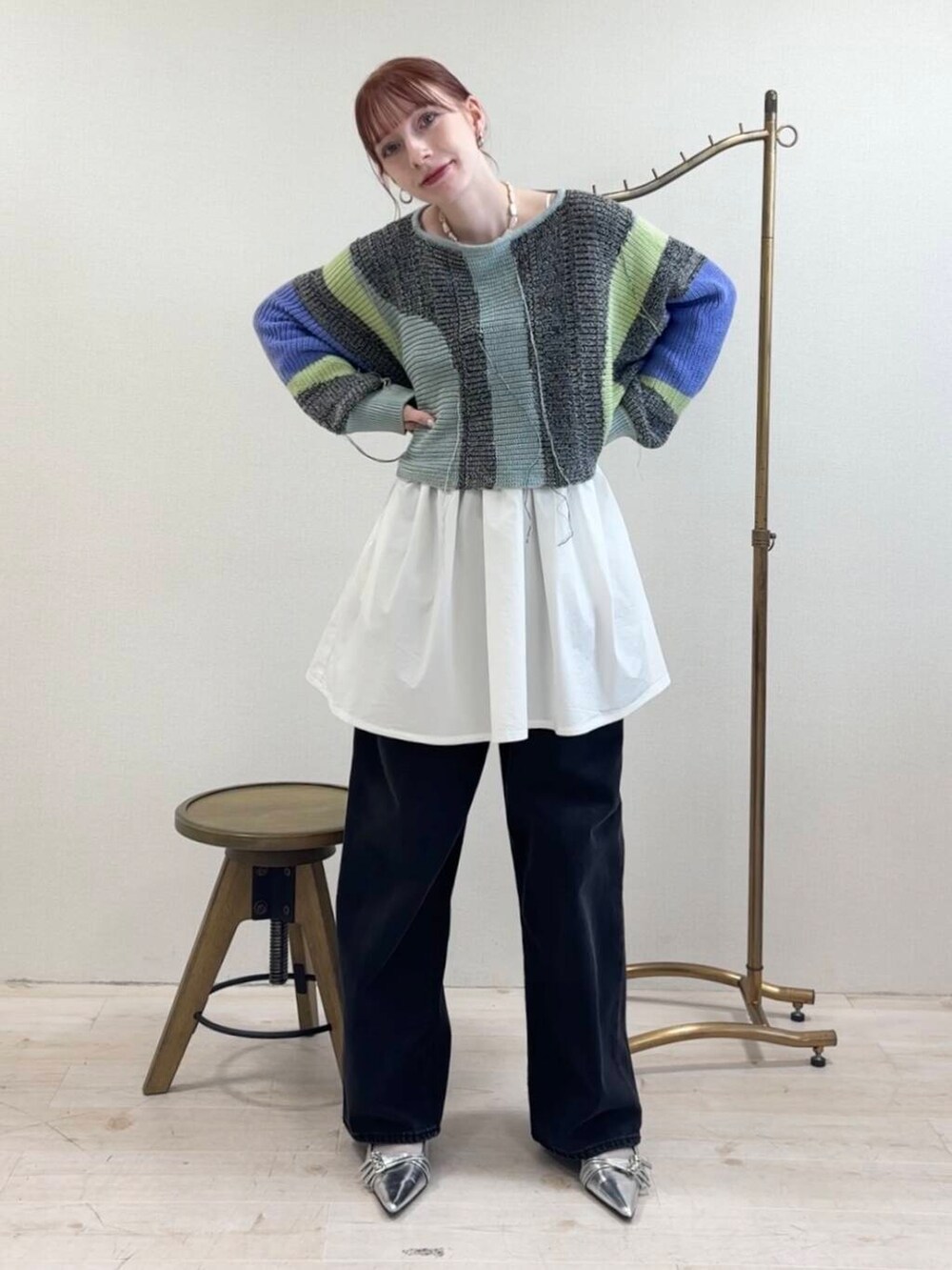 ブラック系のデニムパンツ、ホワイト系のワンピース、グレー系のニット/セーターを着用したレディースの夏コーディネートの2枚目の写真