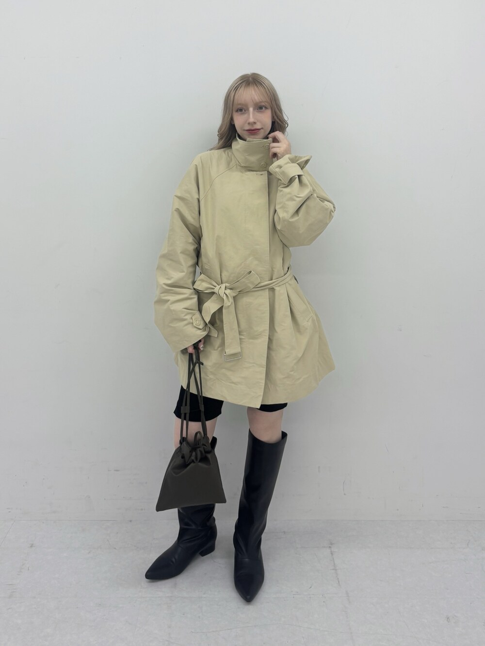 ベージュ系のその他アウター、ブラック系のその他パンツ、ブラック系のブーティを着用したレディースの冬コーディネートの2枚目の写真