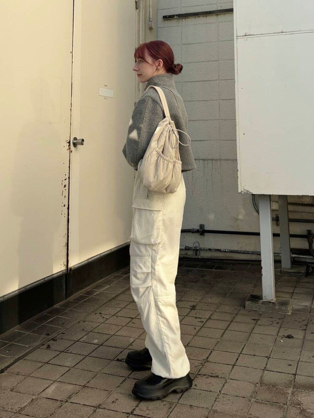 ブラック系のブーツ、ホワイト系のショルダーバッグ、ホワイト系のその他パンツを着用したレディースの冬コーディネートの2枚目の写真