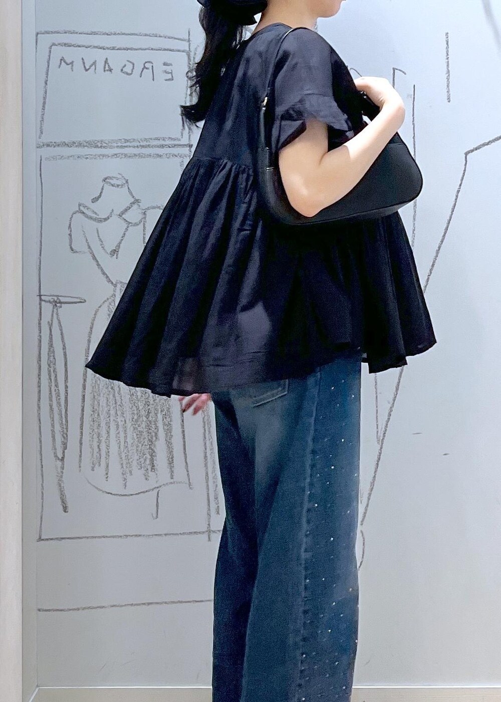 ブラック系のハンドバッグ、ブルー系のデニムパンツ、ブラウン系のサンダルを着用したレディースの夏コーディネートの8枚目の写真