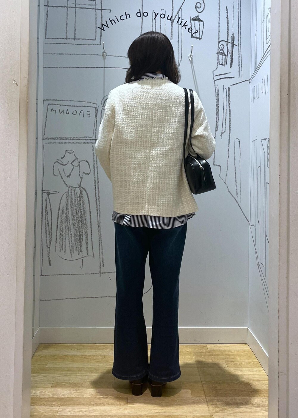 ブルー系のデニムパンツ、ブラック系のブーツ、ブラック系のボストンバッグを着用したレディースの冬コーディネートの3枚目の写真