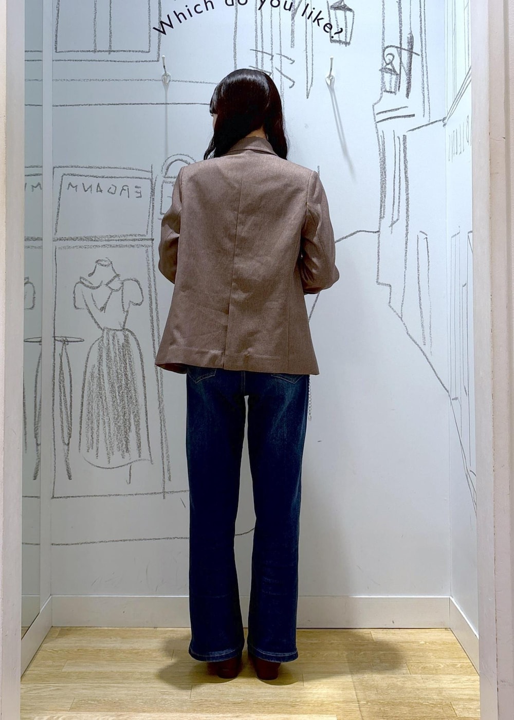 ブルー系のデニムパンツ、ベージュ系のテーラードジャケット、イエロー系のショルダーバッグを着用したレディースの秋コーディネートの4枚目の写真