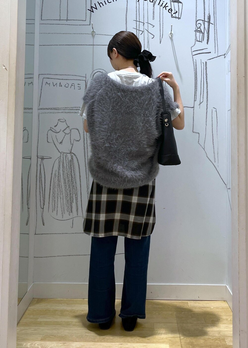 ブルー系のデニムパンツ、ブラック系のショルダーバッグ、グレー系のベストを着用したレディースの夏コーディネートの4枚目の写真