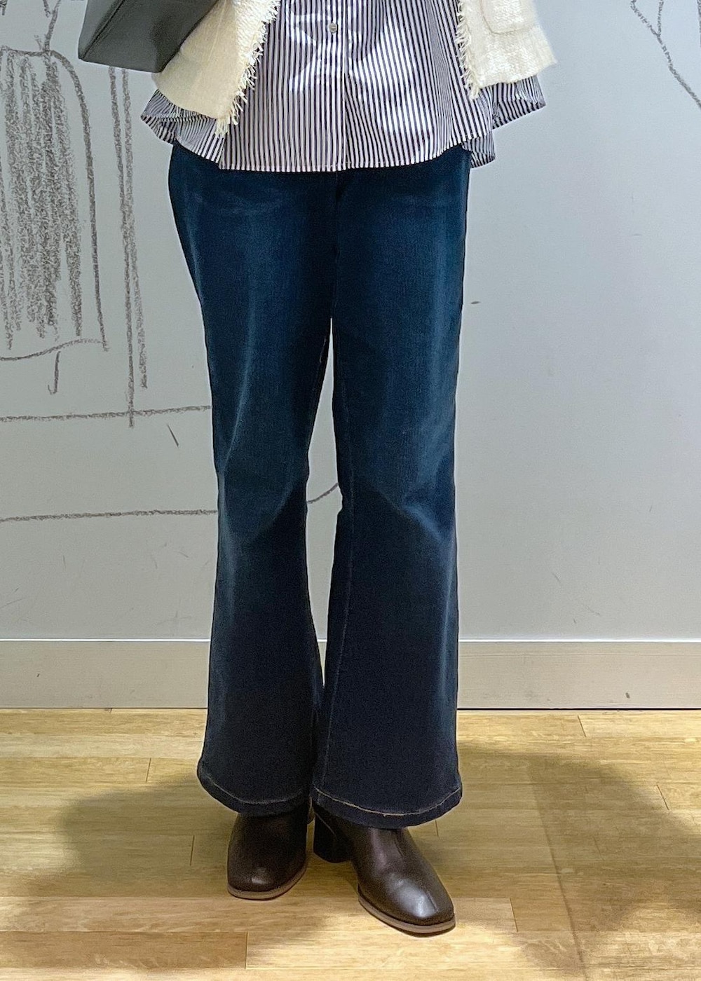 ブルー系のデニムパンツ、ブラック系のブーツ、ブラック系のボストンバッグを着用したレディースの冬コーディネートの6枚目の写真