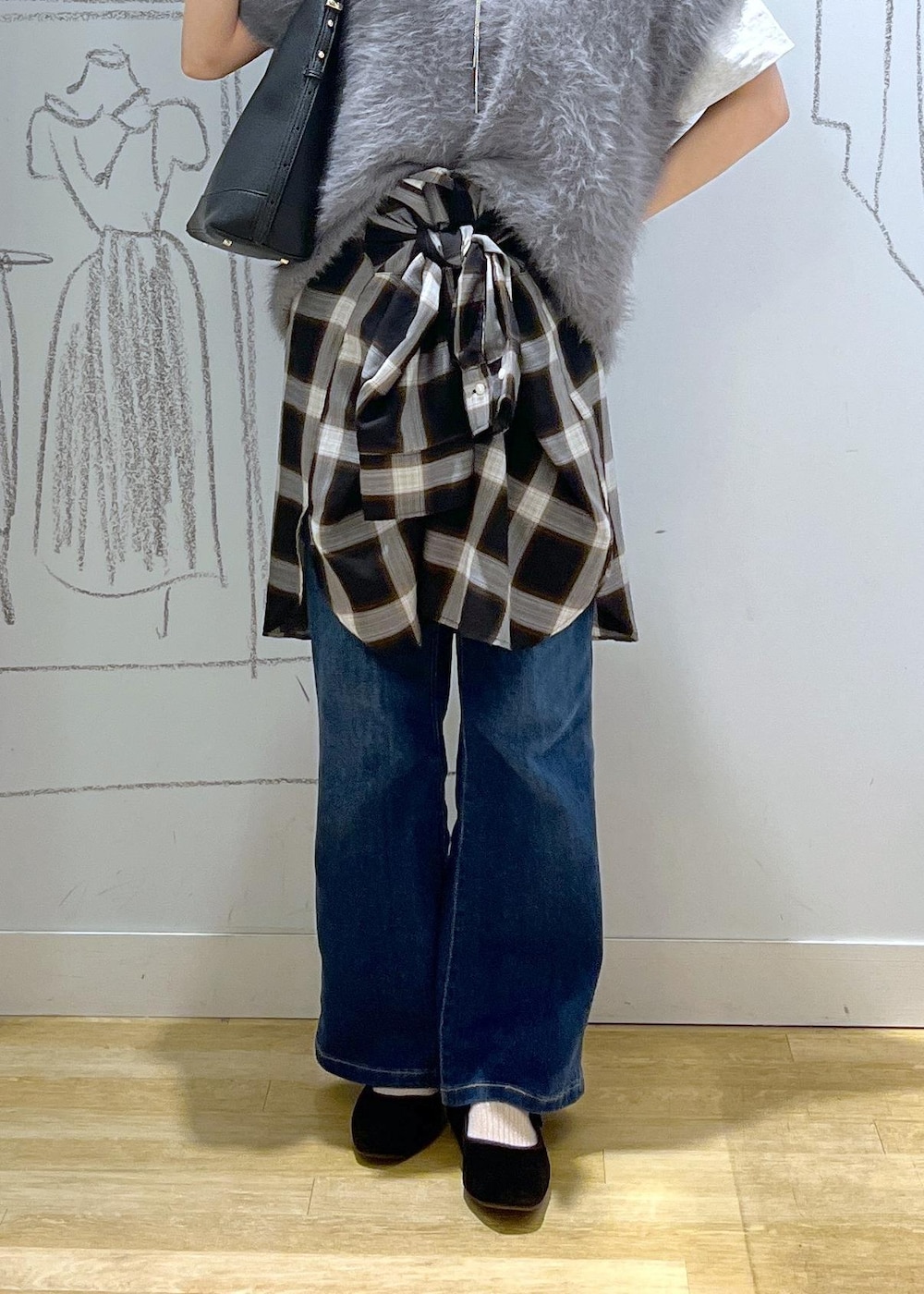 ブルー系のデニムパンツ、ブラック系のショルダーバッグ、グレー系のベストを着用したレディースの夏コーディネートの7枚目の写真