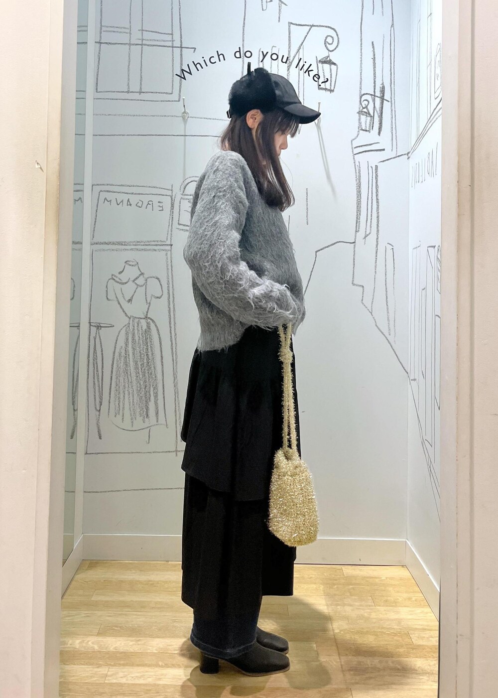 ブルー系のデニムパンツ、ブラック系のブーツ、ブラック系のスカートを着用したレディースの冬コーディネートの4枚目の写真