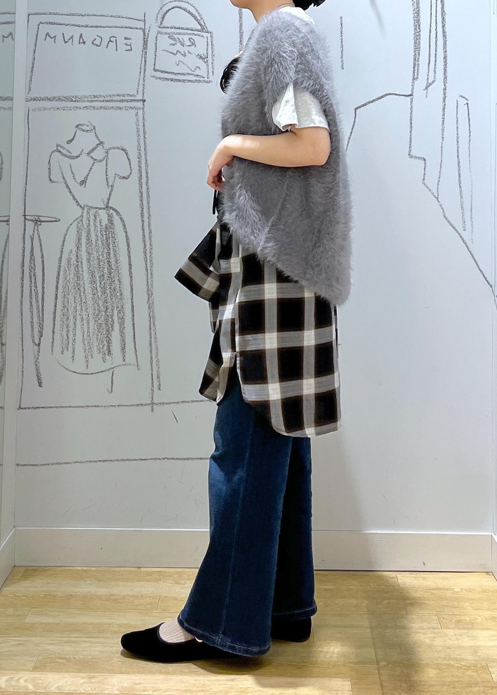 ブルー系のデニムパンツ、ブラック系のショルダーバッグ、グレー系のベストを着用したレディースの夏コーディネートの5枚目の写真