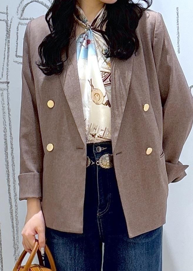 ブルー系のデニムパンツ、ベージュ系のテーラードジャケット、イエロー系のショルダーバッグを着用したレディースの秋コーディネートの6枚目の写真